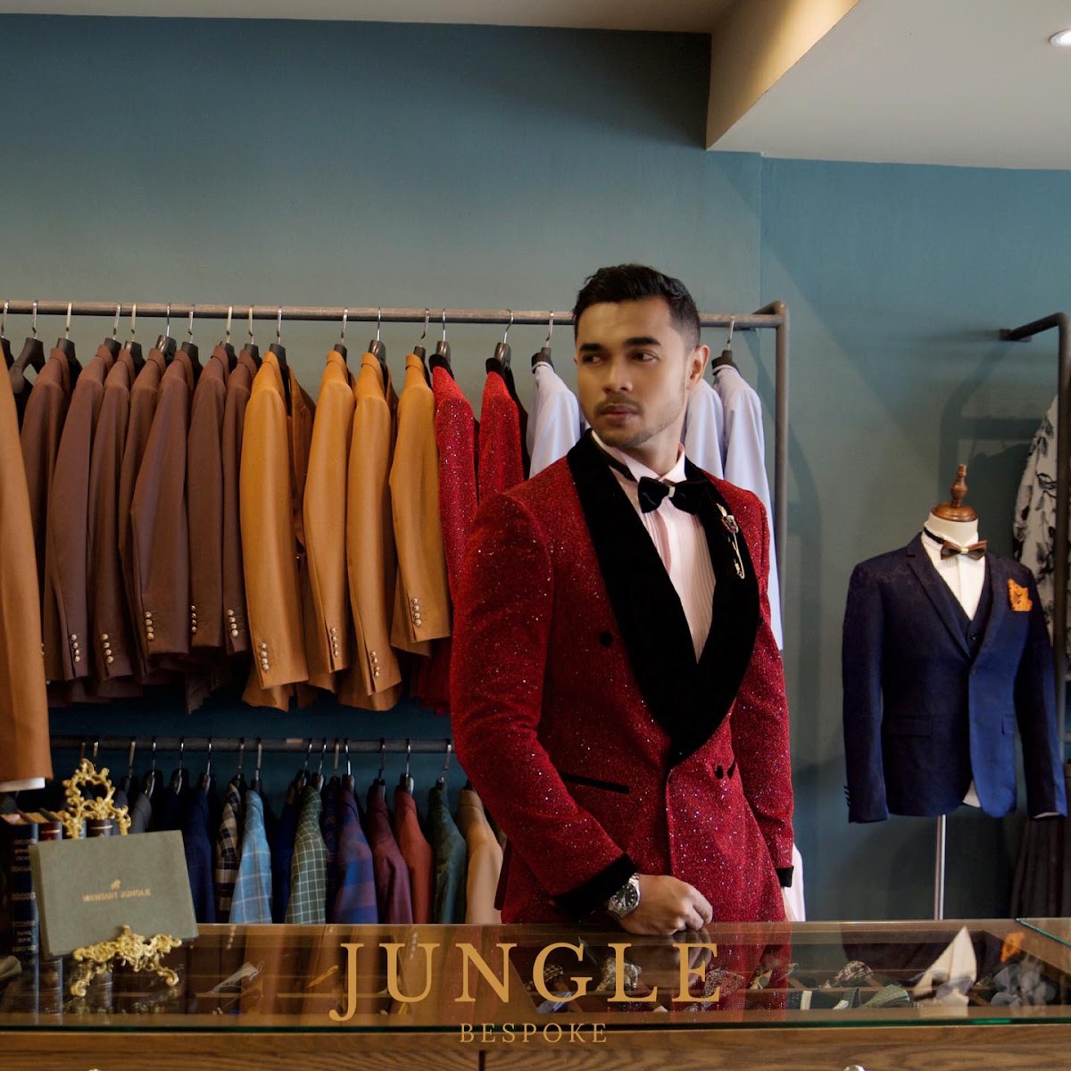 A customer wearing a custom red tuxedo in the shop